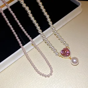 Nahaufnahme einer Perlenkette mit rosa Zirkonia-Herzanhänger und hängender Perle