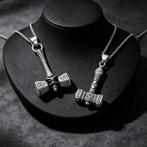 Close-up of retro Viking Mjölnir pendants with intricate Nordic knotwork engraving.
