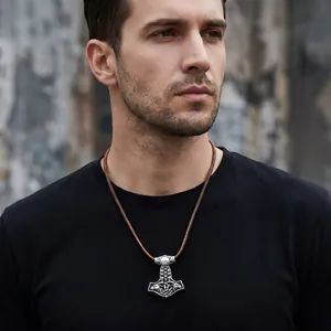 Detailed view of a vintage stainless steel Viking Thor's Hammer pendant worn by a male model
