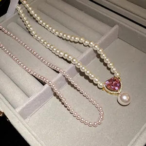 Nahaufnahme der eleganten Perlenkette mit rosa Herz-Kristallanhänger in Schmuckschatulle