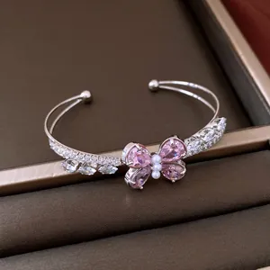 Detailansicht eines eleganten silbernen Schmetterlingsarmbands mit rosa Zirkonia und Perlen.