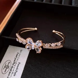 Detailaufnahme eines eleganten Gold-Zirkon-Schmetterlings-Armreifs in einer Schmuckschatulle