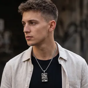 Detailed close-up showing a dark street style double-faced Buddha pendant necklace on a male model.