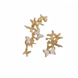 Asymmetrical gold branch ear cuffs with white acetate butterflies and a small pearl accent.