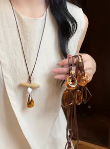 Close-up of vintage resin pendant necklace with leather cord and amber-colored variants