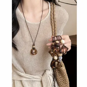 Close-up of retro resin oval pendant necklace with leather cord and ethnic style details