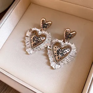 Eleganti orecchini vintage a cuore con bordi increspati in una scatola per gioielli