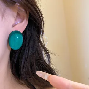 Detailed view of an elegant green oval resin stud earring with a silver needle post