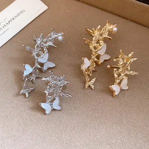 Detailed view of asymmetric butterfly ear cuffs in elegant gold and silver