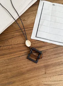 Detailed view of vintage resin pendant necklace with interlocking geometric shapes.