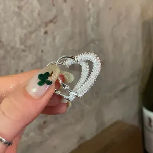 Detailed view of silver heart hoop earrings embellished with delicate white pearls