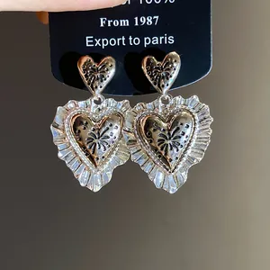 Vista ravvicinata di orecchini a cuore plissettato in stile vintage color argento