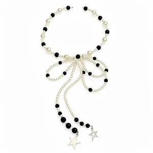 Elegant black and white pearl beaded bow necklace with star tassels, vintage style.