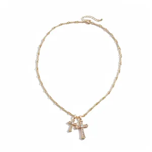 Elegant gold-plated double cross pendant necklace featuring sparkling cubic zirconia stones.