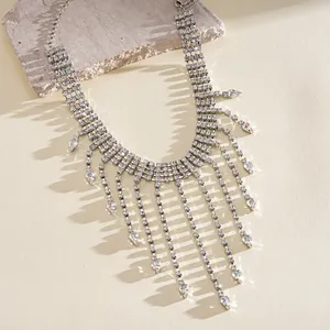 Elegant detail of vintage rhinestone teardrop tassel necklace displayed on a stone prop.