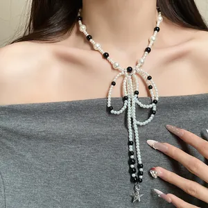 Close-up of French retro bowknot pearl necklace with star charm worn by a model.