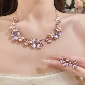 Detailansicht der eleganten lila floralen Emaille-Halskette und Ohrringe am Modell