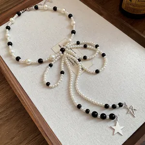 Detailed view of French vintage necklace featuring glass pearls and delicate star pendants