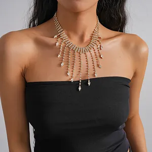 Elegant gold-tone rhinestone tassel necklace with teardrop pendant details on model