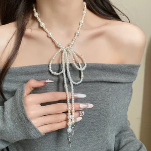 Detailed view of an elegant glass pearl bow tassel necklace with a star pendant on a model