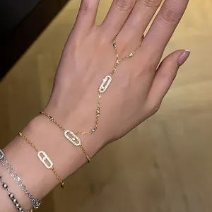 Vista dettagliata di una catena sul dorso della mano dorata con maglie geometriche in zircone