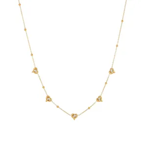 Detail view of a gold-plated stainless steel necklace with five sparkling heart pendants.