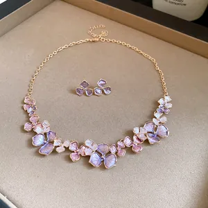 Detailansicht eines eleganten lila Emaille-Blumenschmuck-Sets mit Gold-Finish