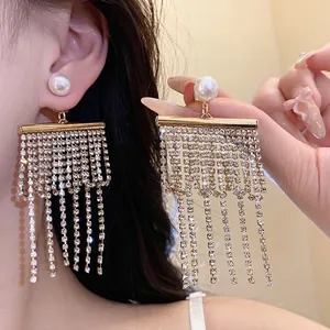 Boucles d'oreilles élégantes avec pompons en perles et strass et tige en argent pur.