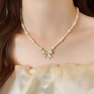 Close-up of an elegant French style pearl necklace with a sparkling zircon bow pendant