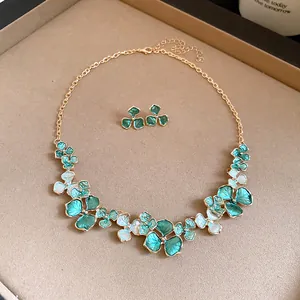 Elegantes Set aus Halskette und Ohrringen mit grünen Emaille-Blumen und goldener Kette.