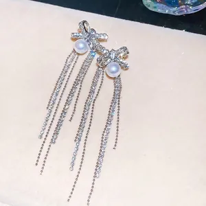 Sparkling zircon bow tassel earrings with pearls and silver needles for a luxurious look