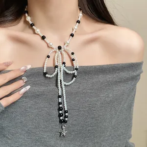 Detail view of French vintage pearl bow necklace with long tassels and star pendant