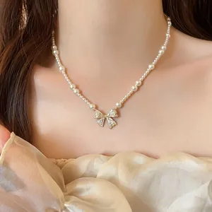 Elegant pearl necklace with a shimmering zircon bow pendant for a chic French look
