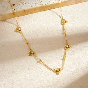 Detail view of a gold-plated stainless steel necklace with crystal-studded heart charms.