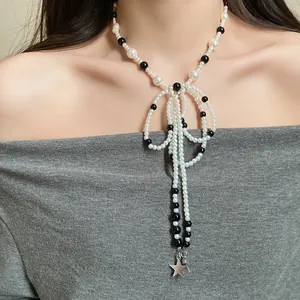 Close-up of elegant pearl beaded bow necklace featuring a silver star tassel on a model