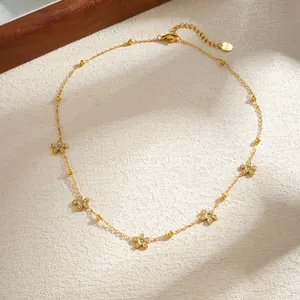Detail view of gold-plated stainless steel necklace with dainty rhinestone flower charms