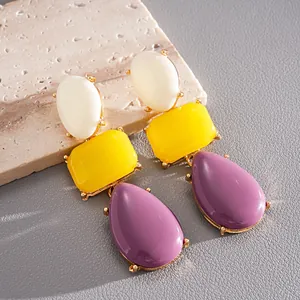 Orecchini a goccia in resina stile dopamina con forme geometriche bianche, gialle e viola.