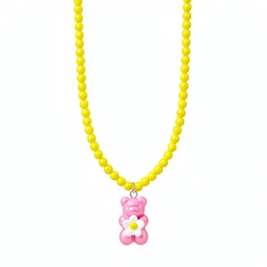 Vibrant pink gummy bear necklace with white flower pendant and yellow beads on white backdrop