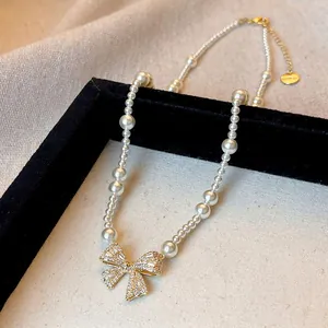 Detailed close-up of French zircon bow pearl necklace with elegant light luxury design style