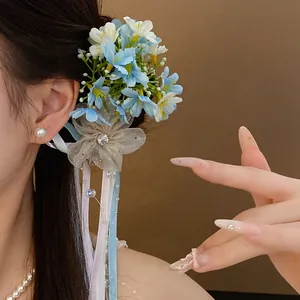 Close-up of a romantic blue and white floral duckbill hair clip with elegant ribbons.