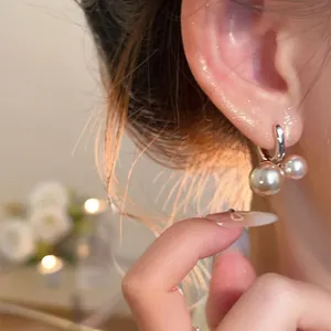 Primer plano de elegantes pendientes de aro con perlas vintage francesas