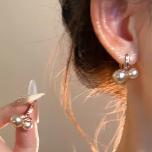 Detalle de pendientes de aro con perlas vintage francesas en elegante oro champán.
