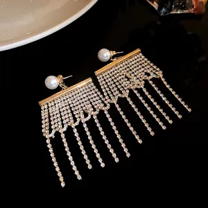 Gros plan de boucles d'oreilles à pampilles en strass avec clous en perles rondes