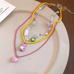 Detail view of layered necklaces with colorful beads, butterfly, and heart pendants.