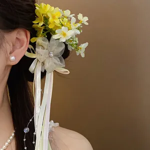 Detailed view of a sweet forest style flower hair clip with long ribbons in a model's hair