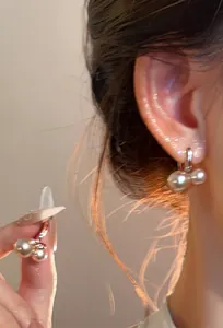 Vista detallada de pendientes de aro dorados retro franceses con elegante diseño de perla doble.
