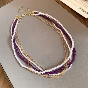 Elegant vintage multi-layer necklace featuring white pearls and purple crystal beads on gold chains