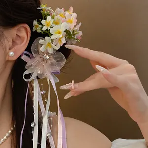 Close-up of romantic floral hair clip with silk ribbon tassels and beads