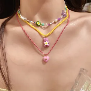 Detail shot of multi-layer colorful beaded necklace with resin bear and heart pendants.