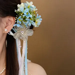 Detailed view of elegant blue floral hair clip with long ribbons on model's hair